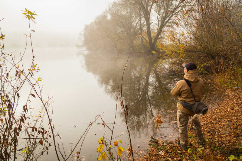 秋季河边钓鱼的男子