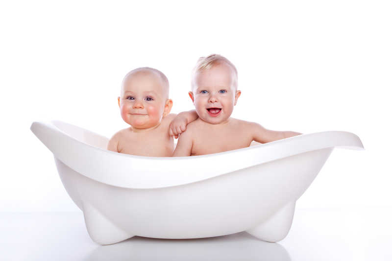 白色澡盆里的两个可爱的婴儿