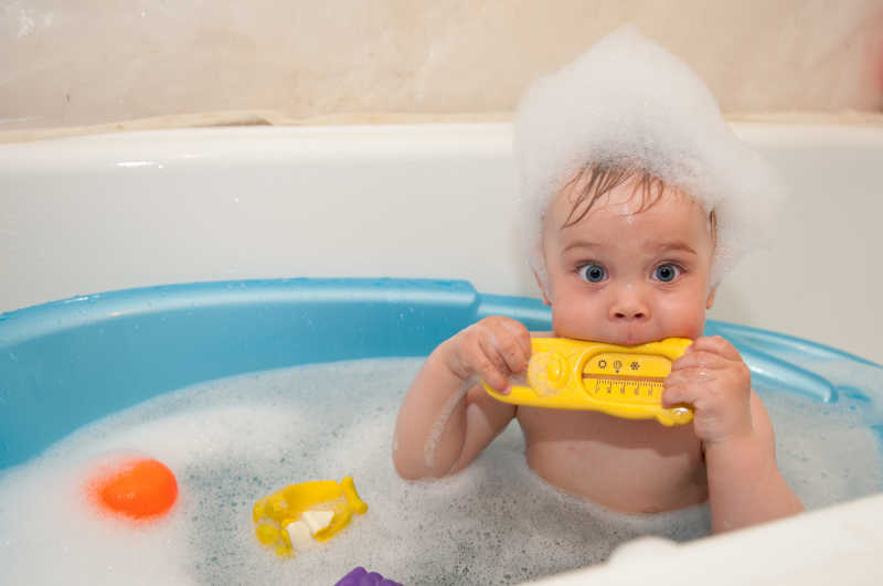 蓝色浴缸里洗澡玩耍的婴儿