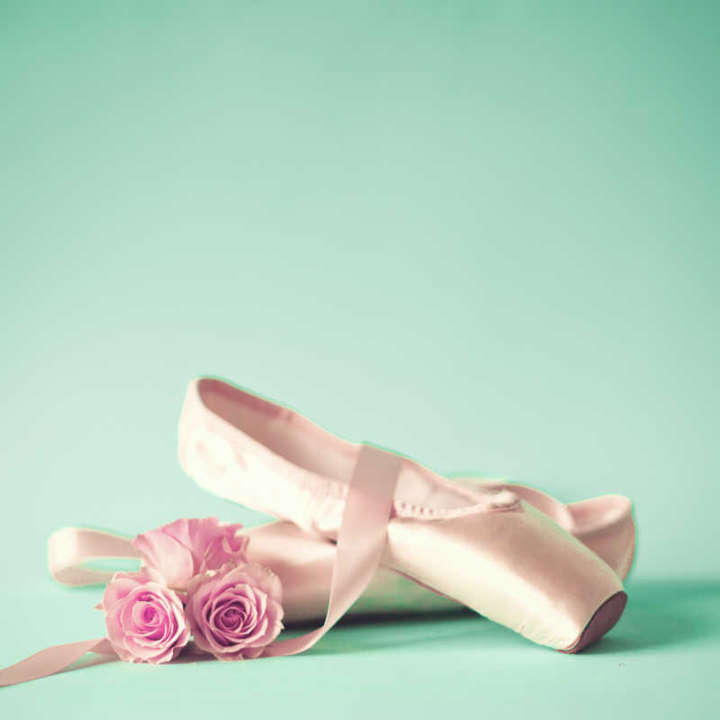 绿色背景下的粉色芭蕾舞鞋