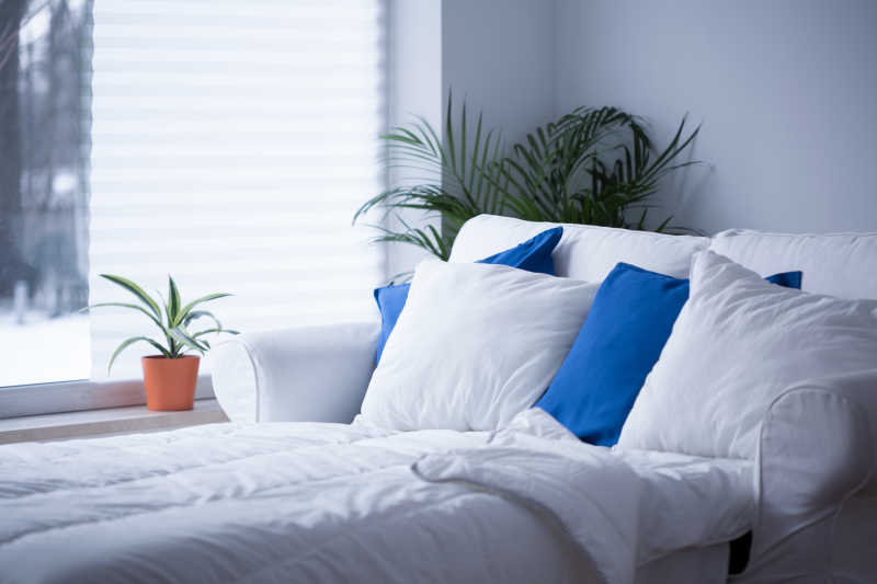 床上放着许多的蓝色和白色枕头