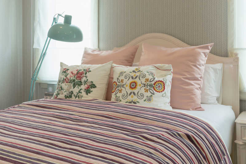 床上放在条纹色的被子和两个白色的枕头