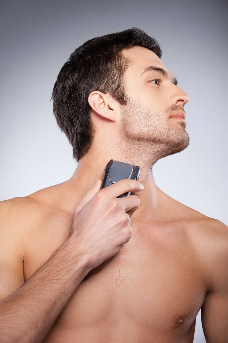 男人使用电动剃须刀剃胡子