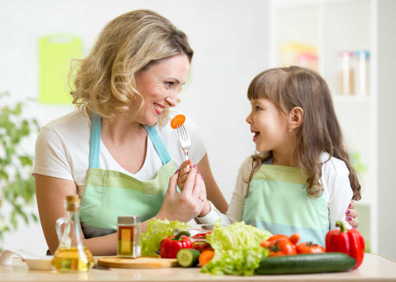 女儿在厨房给妈妈喂食