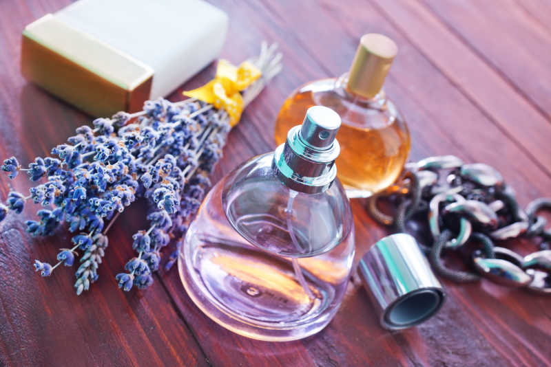 木质桌板上的香水瓶和薰衣草