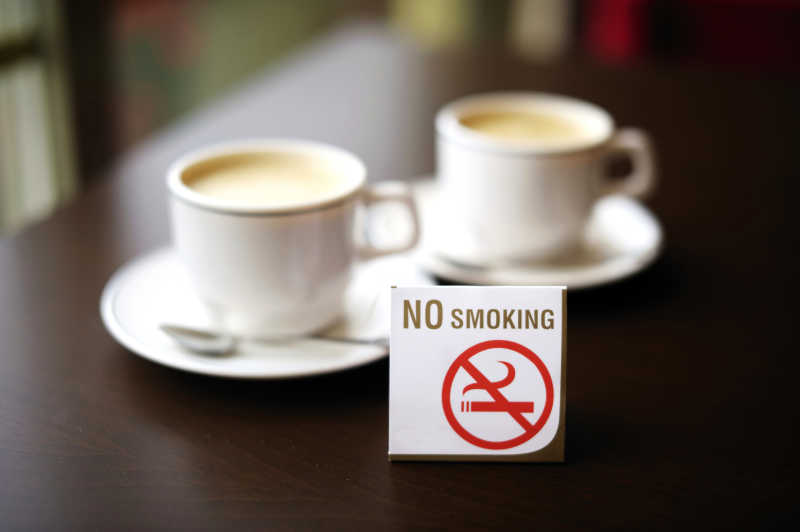 咖啡杯旁边的禁止吸烟牌子