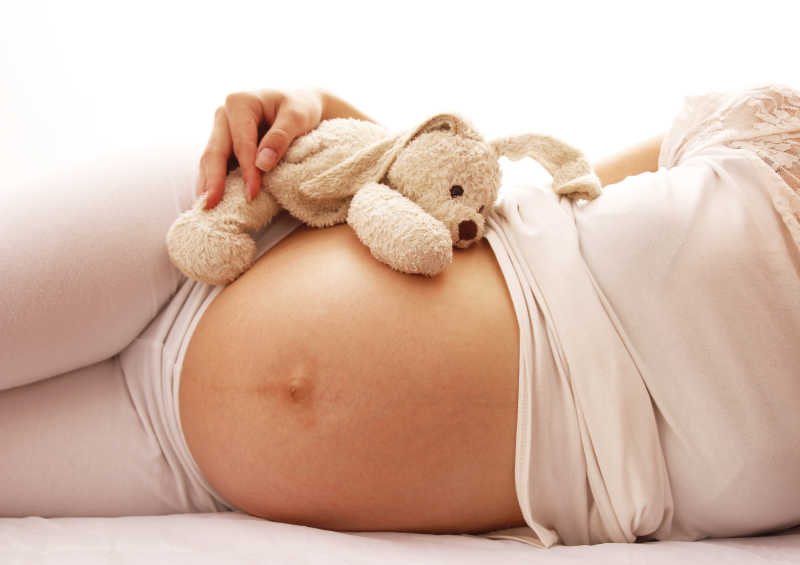孕妇露着肚子躺在床上