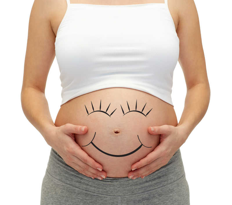 肚子上画着笑脸图案的孕妇