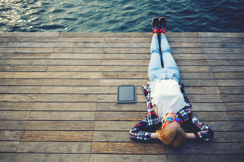 躺在木码头上休息的年轻女子