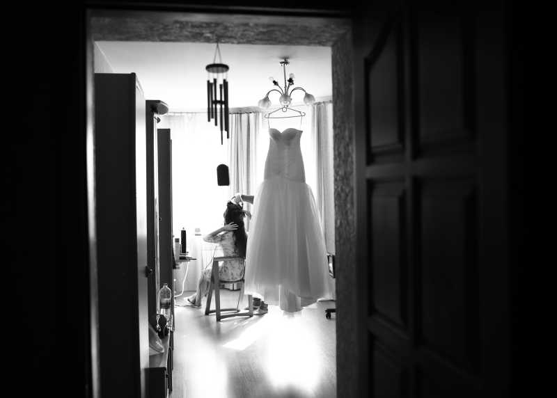 年轻的新娘在化妆镜化妆等待穿上婚纱