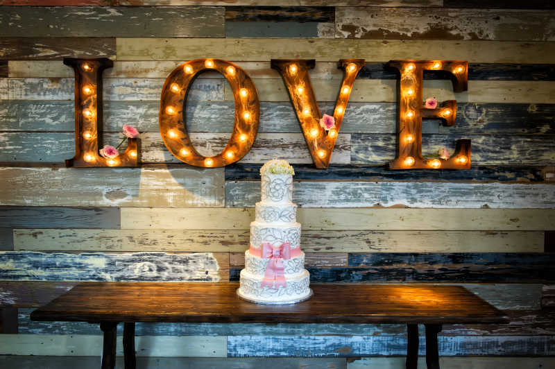 一个爱心婚礼蛋糕与挂在墙上的LOVE