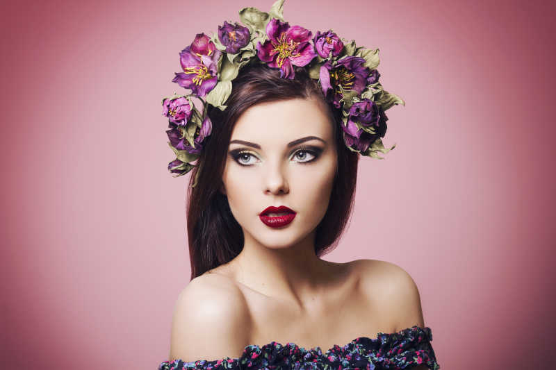 美丽的年轻女子戴着鲜花头巾和亮丽的妆容