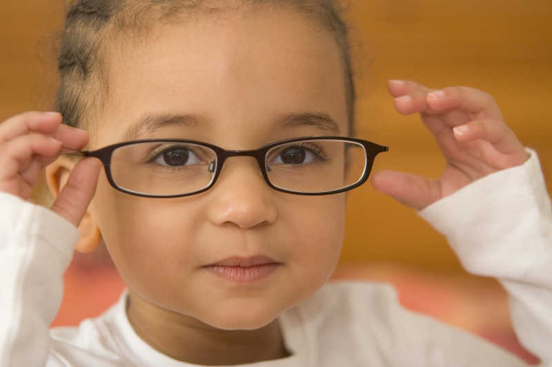 一个混血小女孩戴着稍大的眼镜