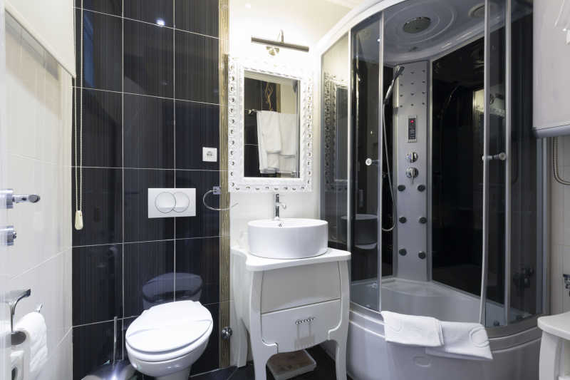 黑白现代风格浴室装修下的玻璃围挡冲凉房和台上洗手盆