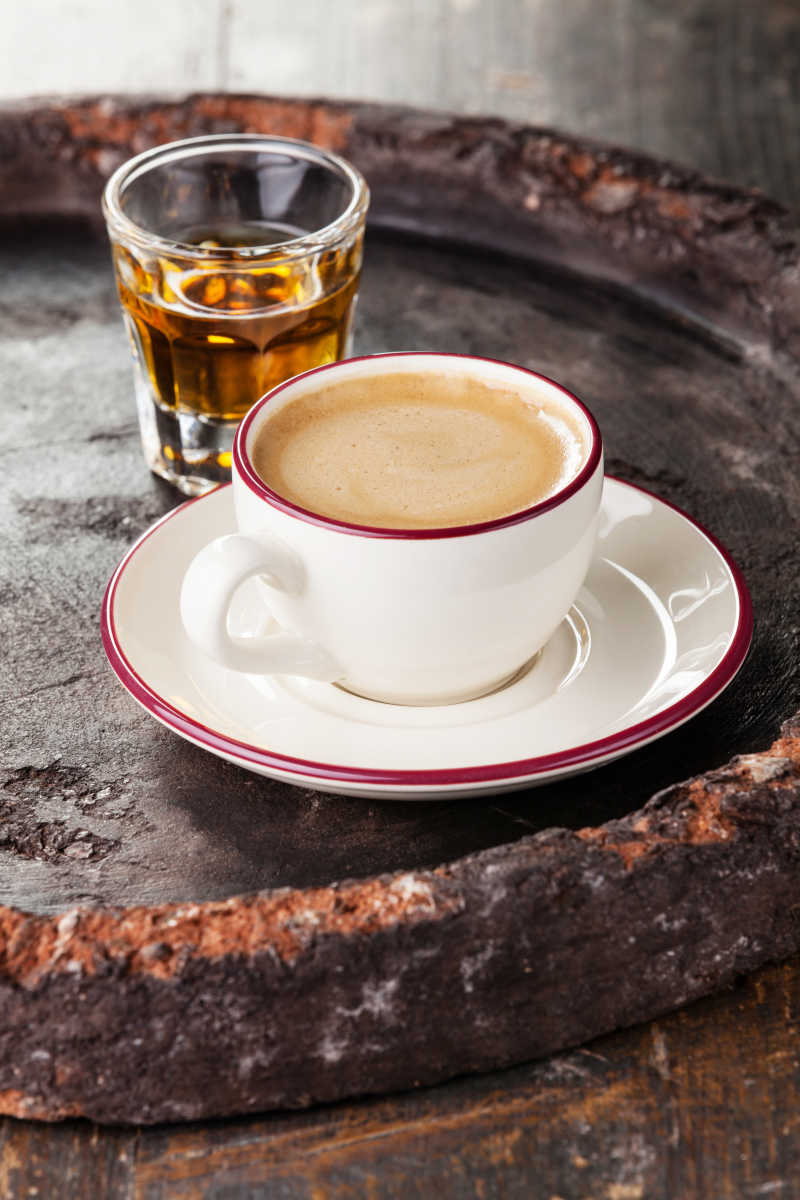 石盘里一杯咖啡和一杯白兰地