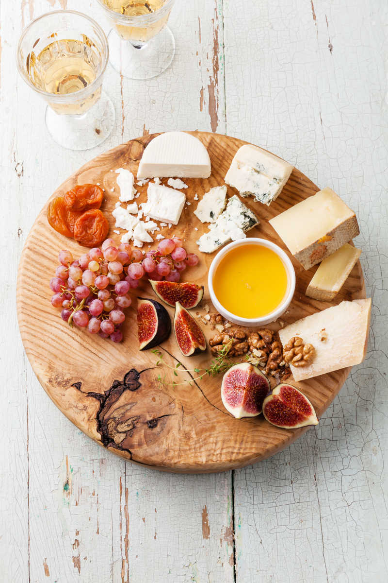 木制砧板上的奶酪芝士水果各种食材