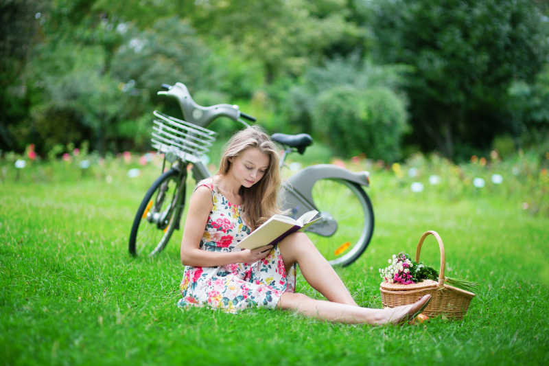 骑自行车到户外看书的美女