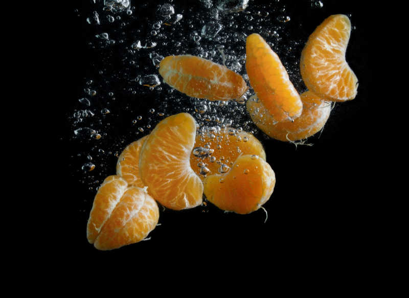 多瓣橘子落入水中气泡的瞬间抓拍