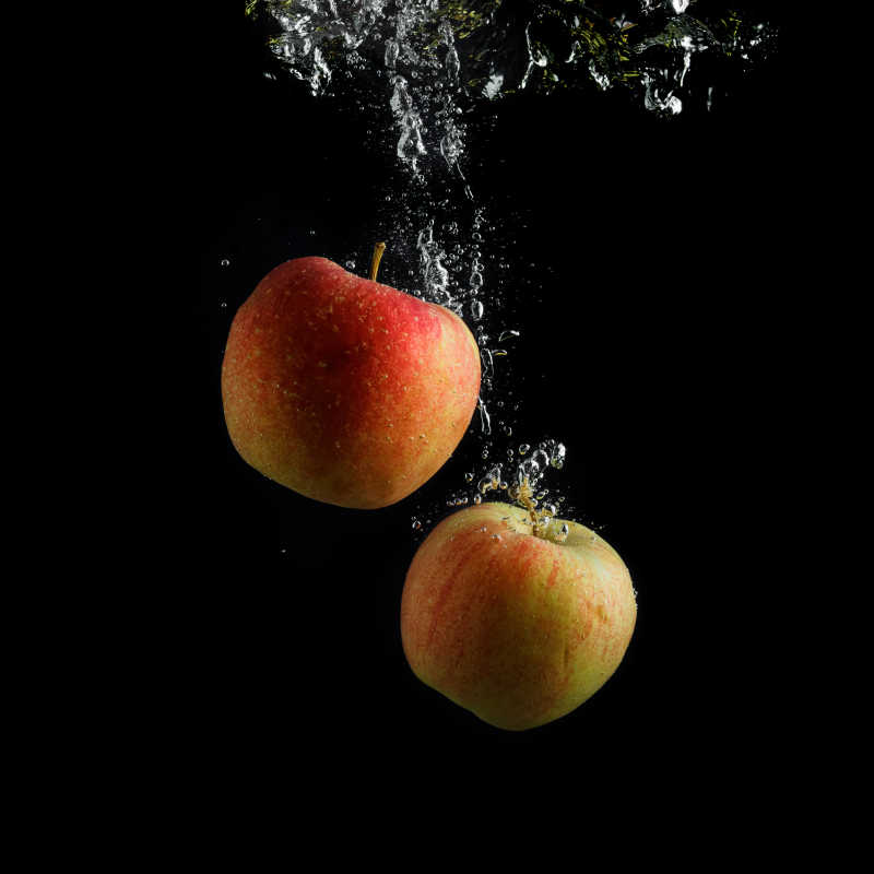 两个苹果泡在水中和气泡特写