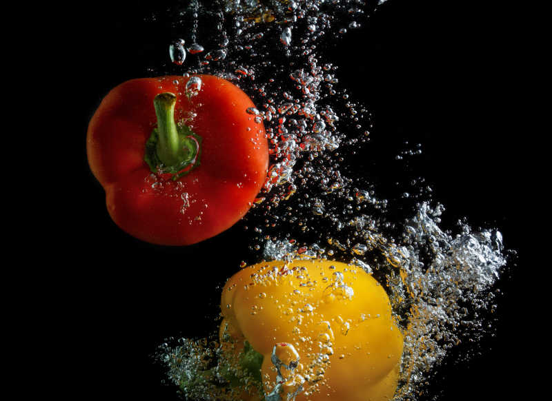 红辣椒和黄辣椒在水中有空气水泡的镜头