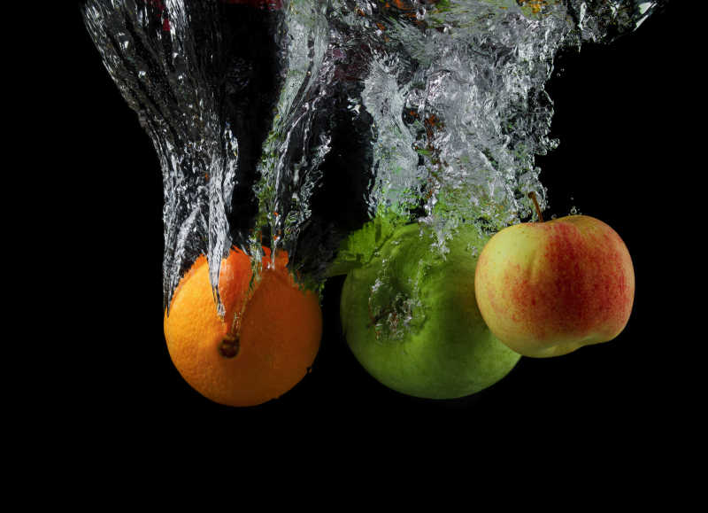 苹果和桔子掉在水中的镜头