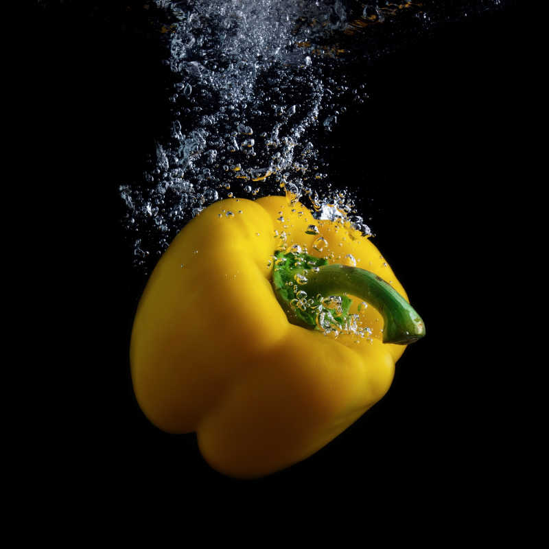 黄色甜椒在水中引起气泡瞬间