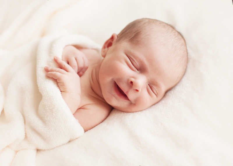 睡着微笑的新生婴儿