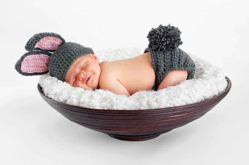 大碗里穿着兔子衣服的睡着的宝宝