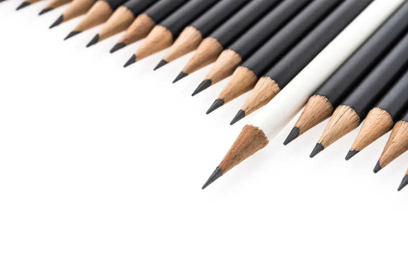 白色背景上的黑色铅笔中夹着一只白色铅笔