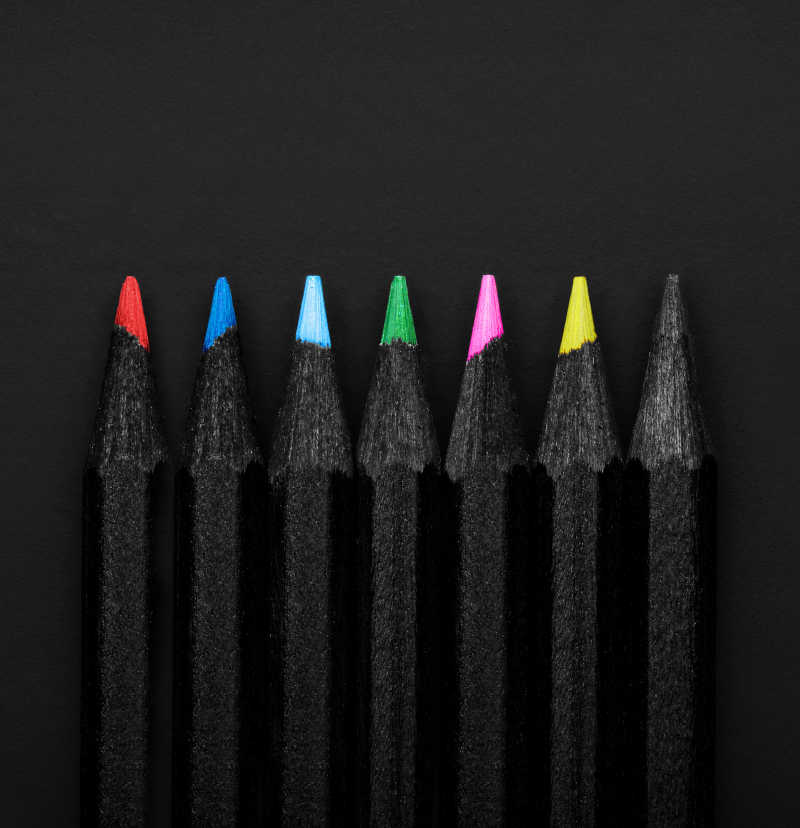 黑色背景上的黑色包装的彩色铅笔