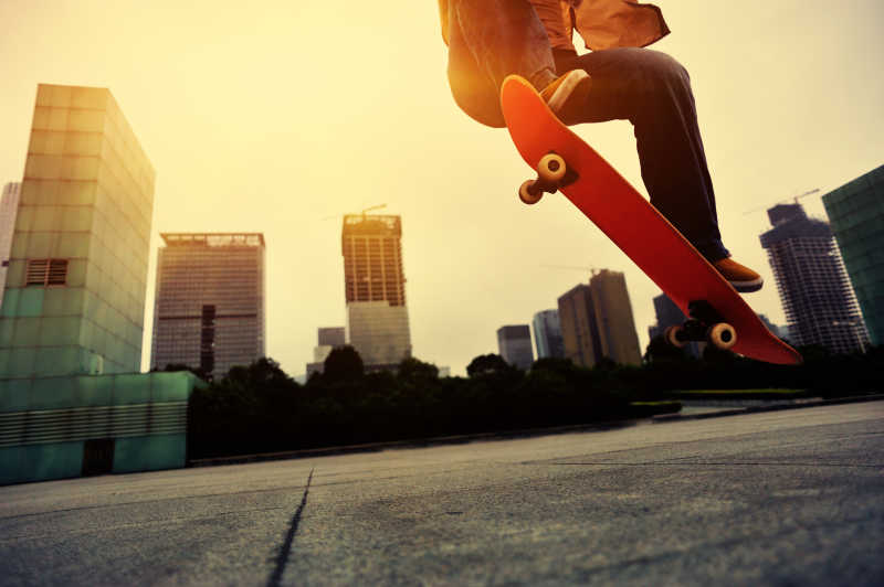 城市街头玩滑板跳跃的年轻人