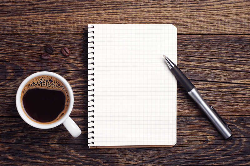 木桌上的咖啡和笔记本
