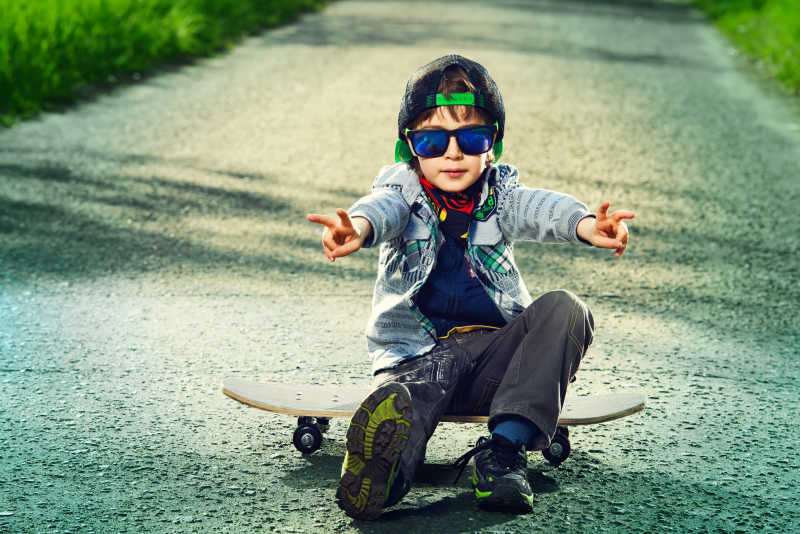 一个7岁的男孩在街上坐着滑板