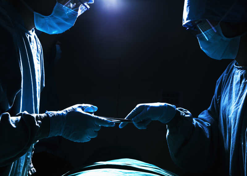 两个外科医生在手术过程中传送手术器械