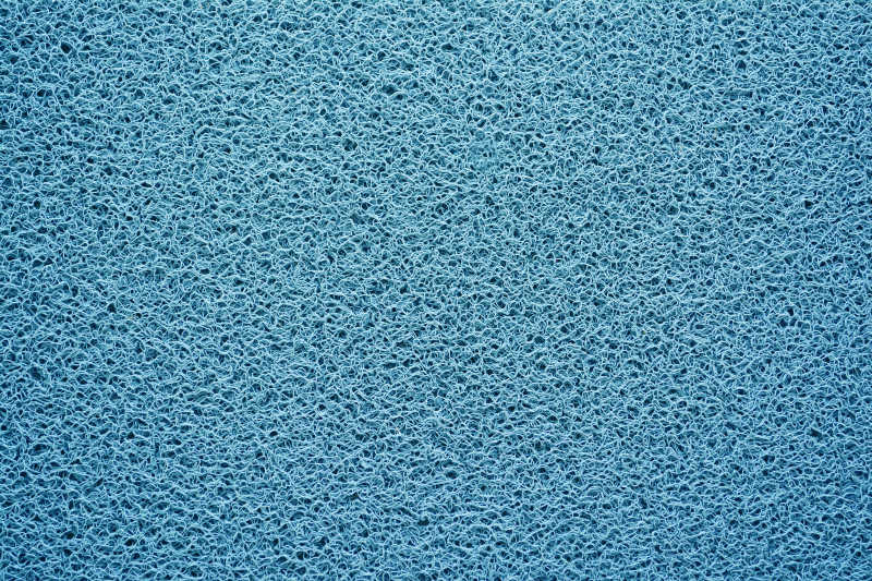 蓝色纹理背景的地毯或门垫特写