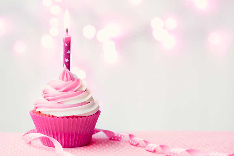 插着蜡烛的粉红色的生日蛋糕特写