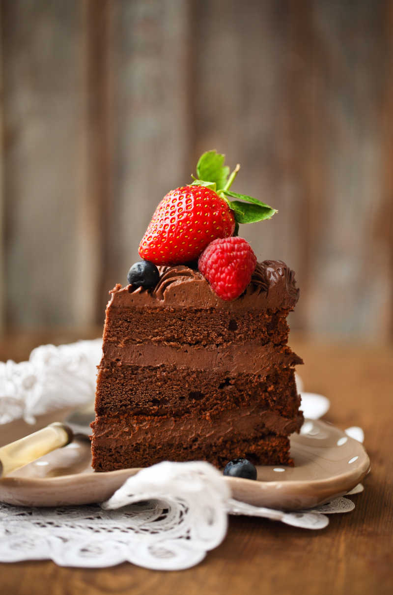 一块上面有糖霜和新鲜浆果的巧克力蛋糕
