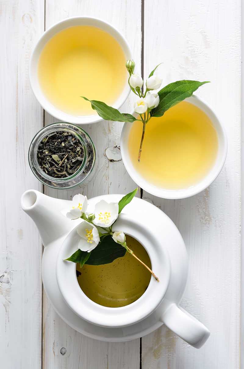 白色茶壶茶杯里的绿茶