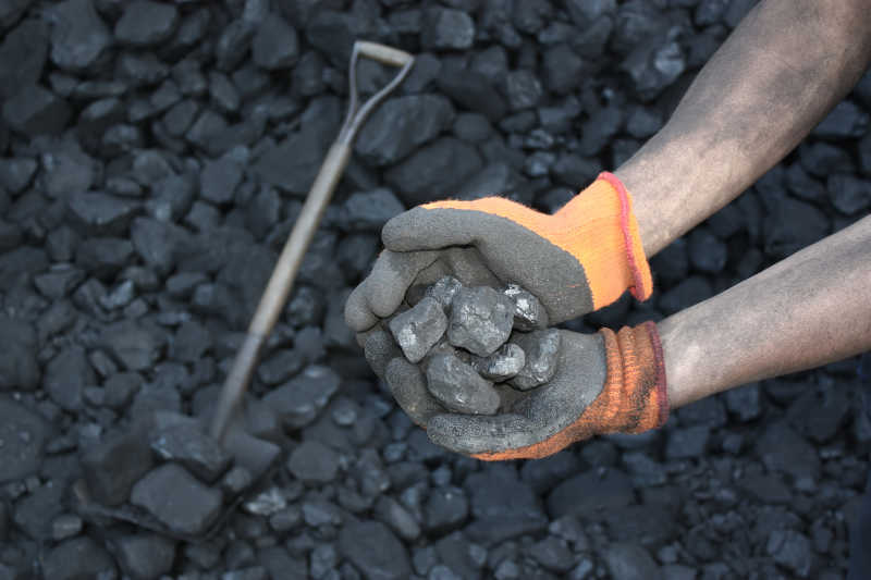 煤炭背景下的拿煤块的双手