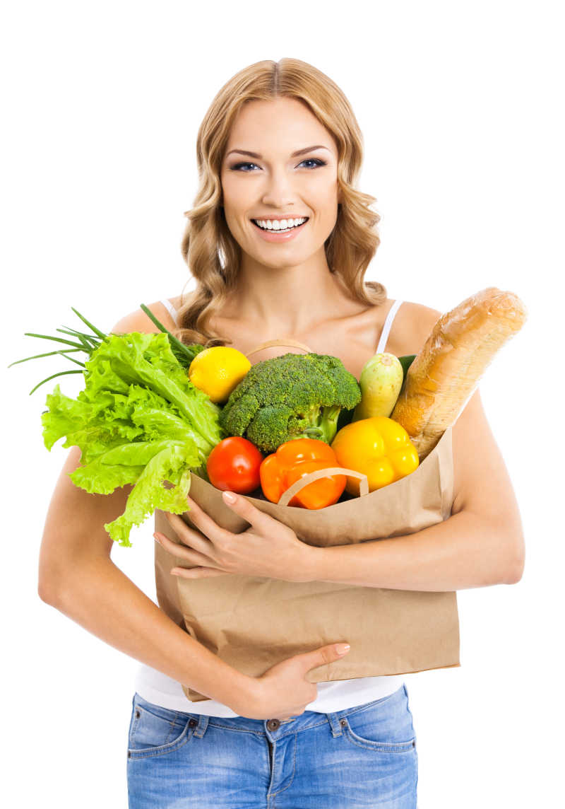 白色背景下抱着一袋蔬菜的女人