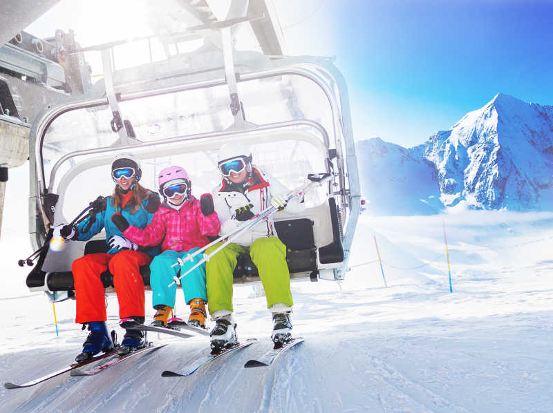 大人与小孩开心的坐着滑雪升降机