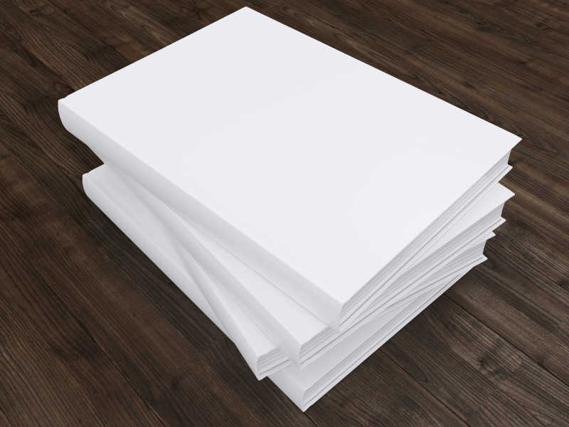 木制桌面上堆放在一起的白色书
