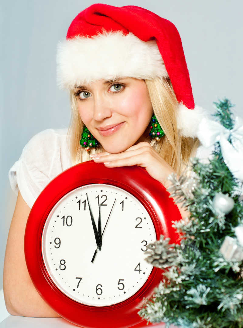穿着圣诞服饰的女人手里拿时钟