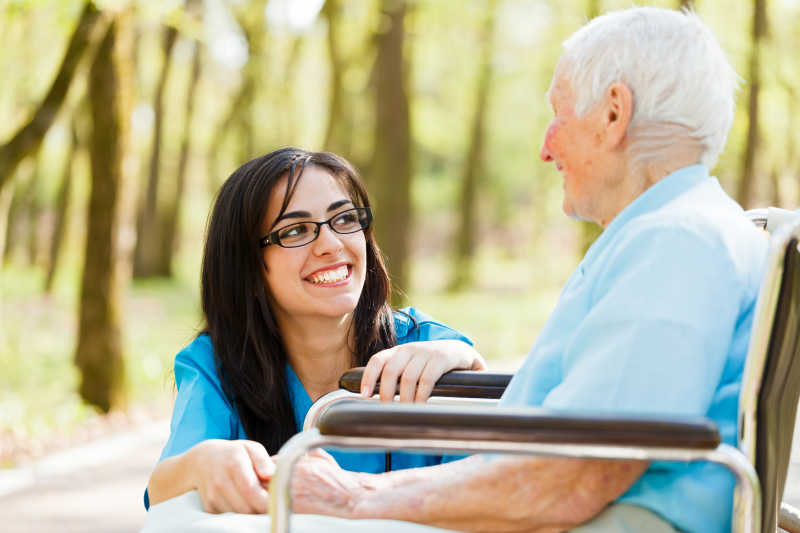 好心护士与轮椅上的老年患者开怀大笑