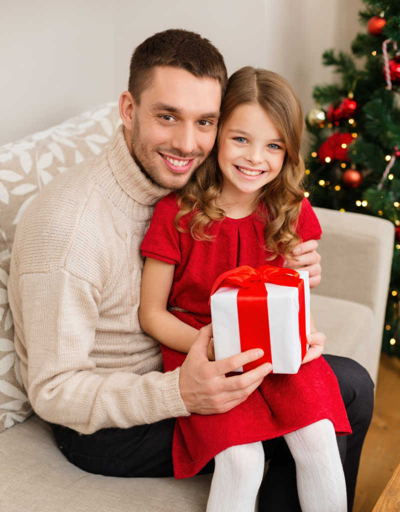 微笑父亲和女儿抱着礼品盒