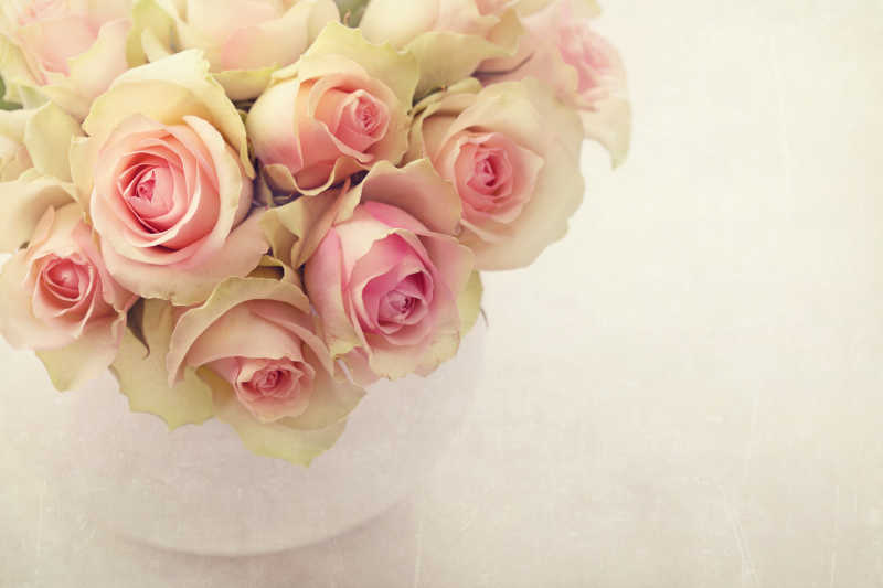 白色花瓶里的白粉玫瑰花束