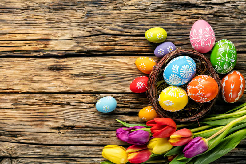 木桌上的复活节彩蛋和彩色郁金香