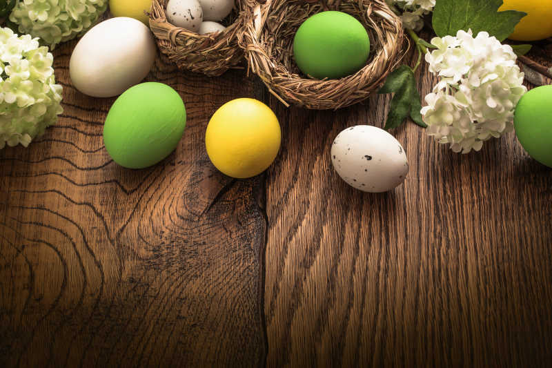 灰色木制背景中白绿黄相间复活节彩蛋