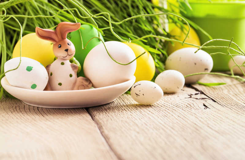木板上盘中复活节彩蛋和兔子装饰  