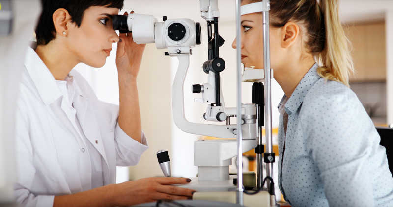 验光师在帮助配镜患者或客户检查视力